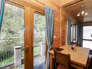 A dining room with a table and chairs at Elm Lodge in Keswick
