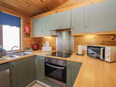 A kitchen with appliances and cabinets at Elm Lodge in Keswick