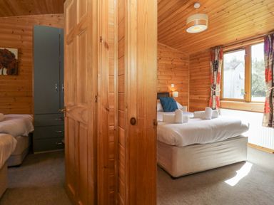 A bedroom with a bed and wardrobe at Elm Lodge in Keswick