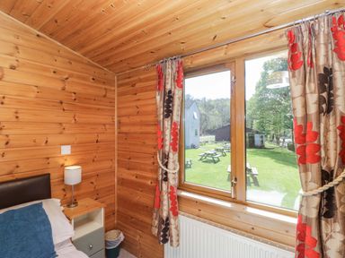 A bedroom with a bed and window at Elm Lodge in Keswick