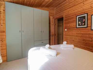 A bedroom with a bed and wardrobe at Elm Lodge in Keswick