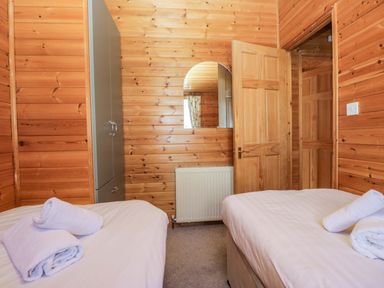 A bedroom with twin beds and a wardrobe at Elm Lodge in Keswick