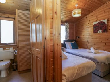 A bedroom with two single beds and a bathroom at Elm Lodge in Keswick
