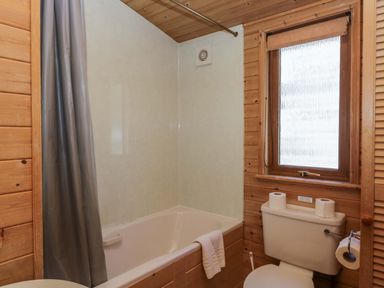 A bathroom featuring a bathtub and toilet at Elm Lodge in Keswick