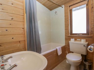 A bathroom with a bathtub, toilet, and sink at Elm Lodge in Keswick