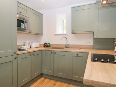 A kitchen with cabinets and appliances at Riverside Cottage No 5 in Keswick