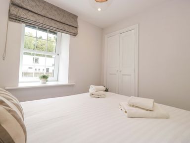 A bedroom with towels on the bed at Riverside Cottage No 5 in Keswick