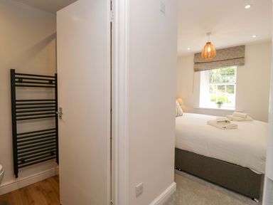 A bedroom with a bed and window at Riverside Cottage No 5 in Keswick