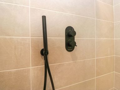 A shower panel and hose in a bathroom at Riverside Cottage No 5 Keswick