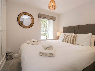 A bedroom with a bed and lamp at Riverside Cottage No 5 in Keswick