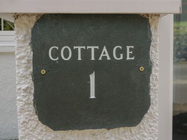 A sign with the text cottage 1 on a wall at Garden Cottage No 1 in Keswick