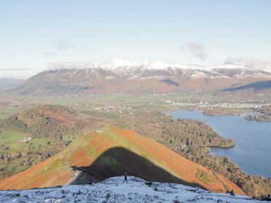 A mountain landscape with snow on peaks and a lake in the valley at Briery House in Keswick