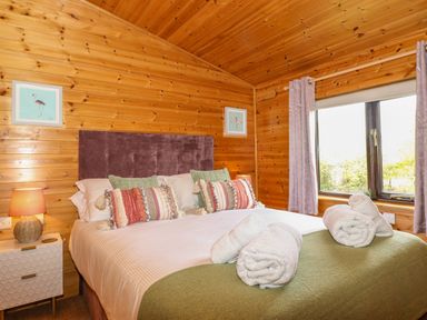 A bedroom with a bed with cushions and towels on at Derwent Lodge in Keswick