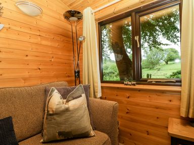 A sitting room with a sofa and window at Derwent Lodge in Keswick