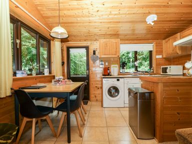 A kitchen with a table and chairs at Derwent Lodge in Keswick