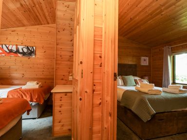 A bedroom with two beds and a window at Derwent Lodge in Keswick