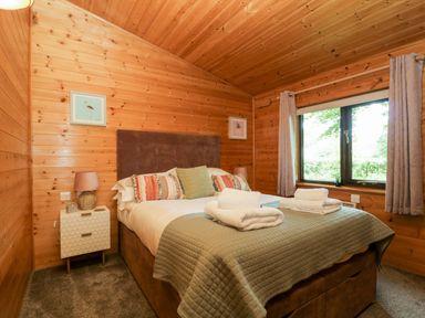 A bedroom with a bed and bedside table at Derwent Lodge in Keswick