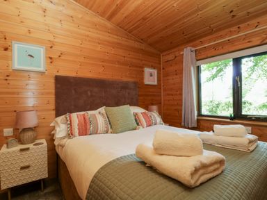 A bedroom with a bed and side table at Derwent Lodge in Keswick
