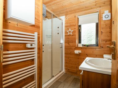 A bathroom with a shower and sink at Derwent Lodge in Keswick