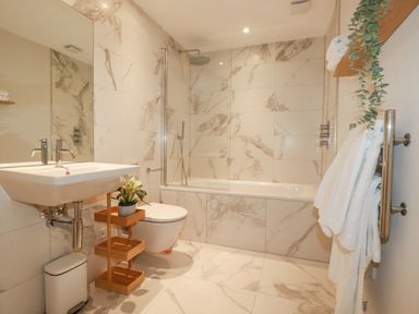 A bathroom with a sink toilet bathtub towels and plants at 11 Ebbtide in Porth