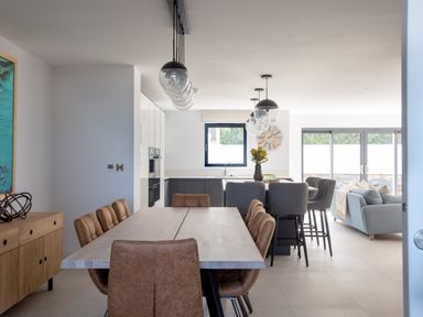 A dining table with brown chairs in a kitchen and living area at 12 Tintagel Terrace in Port Isaac