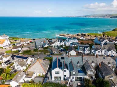 A coastal village with houses and the sea in the background at 12 Tintagel Terrace in Port Isaac