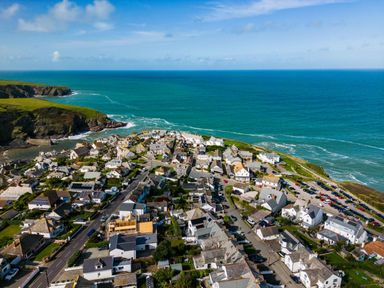 A coastal village with houses roads and parked cars near the ocean at 12 Tintagel Terrace Port Isaac