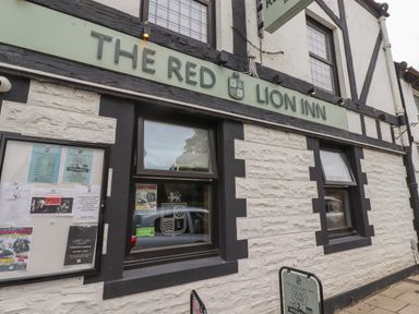 Exterior of The Red Lion Inn with signage windows and notice board at Lark Rise in Alnmouth