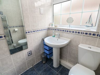 A bathroom with a sink toilet mirror and window at Badger Sett in Granite Henge near Looe near Polperro