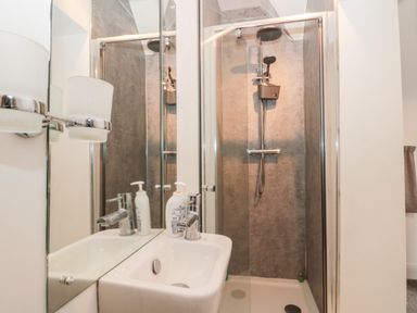 A bathroom with a sink and a shower area with a glass door at Castle Manor in Scarborough
