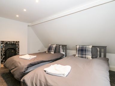 A bedroom with two single beds and a small fireplace at Castle Manor in Scarborough