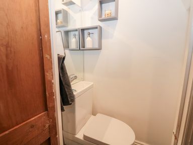 A small bathroom with a toilet and a sink integrated into the toilet tank at Castle Manor in Scarborough