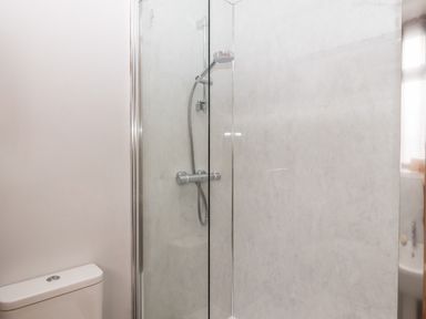 A bathroom with a toilet and a glass-enclosed shower at Mabel's View in East Allington Devon