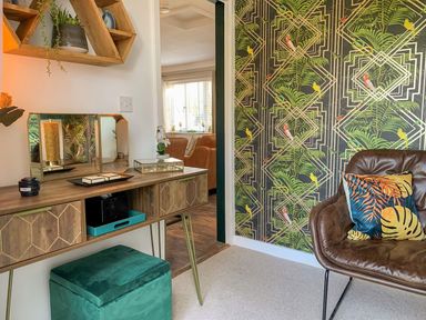 A room with a wooden console table with a mirror and decor next to a brown leather chair with a patterned pillow at Inny Brook Burrow Davidstow near Camelford