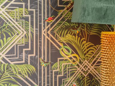 A close-up of patterned wallpaper with green leaves butterflies and a snake beside a green lampshade and golden textured lamp at Inny Brook Burrow Davidstow near Camelford