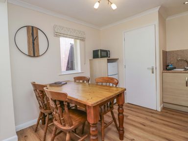 A dining room with a table and chairs at Chestnut Timber Lodge in Keswick