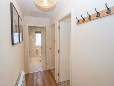 A hallway with coat hooks and doors at Chestnut Timber Lodge in Keswick