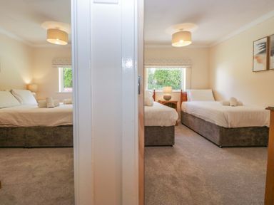A bedroom with two beds and a window at Chestnut Timber Lodge in Keswick