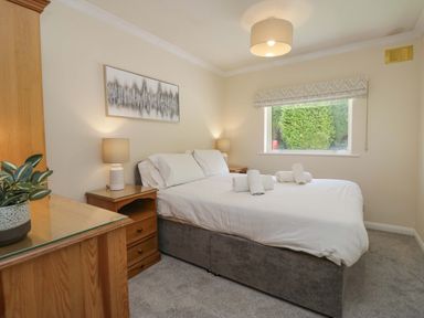 A bedroom with a bed and bedside lamps at Chestnut Timber Lodge in Keswick