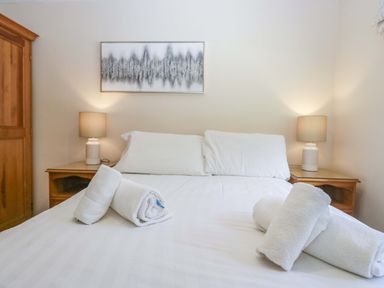 A bedroom with a bed and towels arranged on it at Chestnut Timber Lodge in Keswick