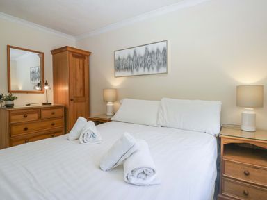 A bedroom with a bed and lamps at Chestnut Timber Lodge in Keswick