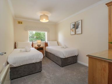 A bedroom with two beds and a lamp at Chestnut Timber Lodge in Keswick