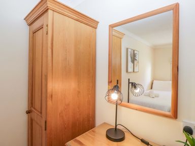 A bedroom with a wardrobe and a mirror at Chestnut Timber Lodge in Keswick