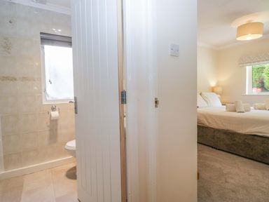 A bathroom with a toilet and door at Chestnut Timber Lodge, Keswick