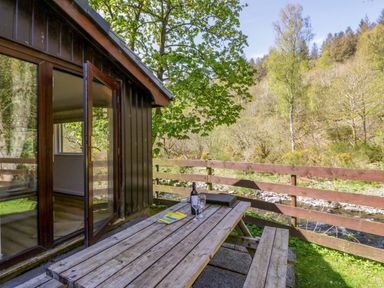 An outdoor seating area with a table and chairs at Chestnut Timber Lodge in Keswick