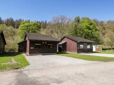 Two wooden cabins with trees in an outdoor area at Chestnut Timber Lodge in Keswick