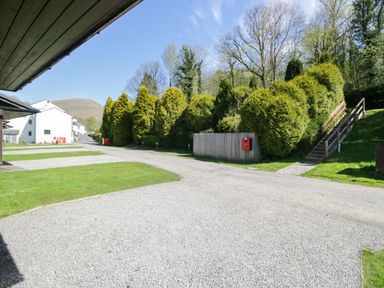 An outdoor area with gravel path and hedges at Chestnut Timber Lodge in Keswick