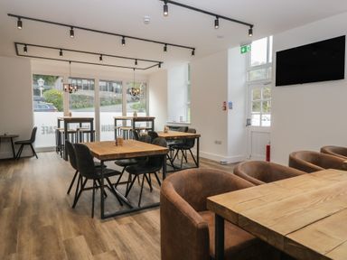 A café with wooden tables and chairs at Dogwood Timber Lodge in Keswick