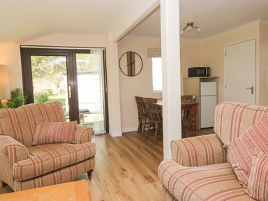 A living room with a sofa, table, and fridge at Dogwood Timber Lodge, Keswick