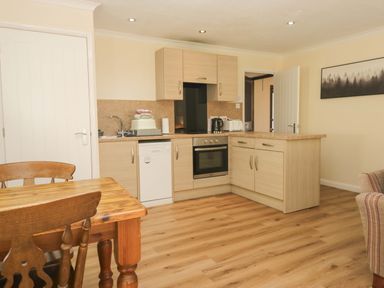 A kitchen with a dining table and appliances at Dogwood Timber Lodge in Keswick